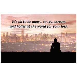 A person sitting on the ground with a city in the background