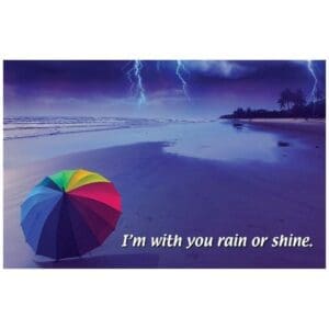 A rainbow umbrella on the beach with lightning in the background.
