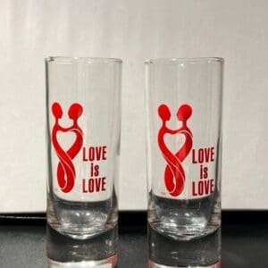 Two glasses with a red ribbon and the words 