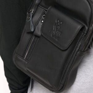 A person with a black bag on their shoulder.