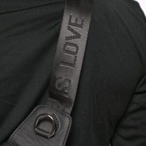 A close up of the shoulder strap on a black jacket