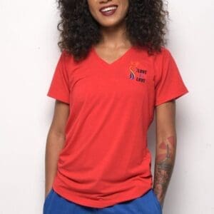 A woman wearing red shirt and blue shorts.