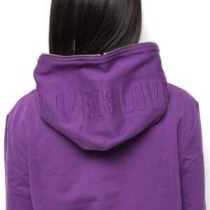 A person wearing a purple jacket with the word 